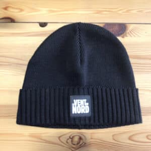 A black Merino Winter Hat - Le Vent du Nord with a logo of "le vent du nord" on it.